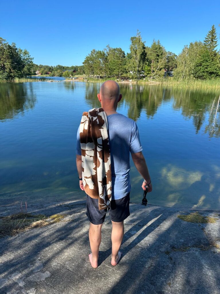 Standing in fron of a lake looking at the forest