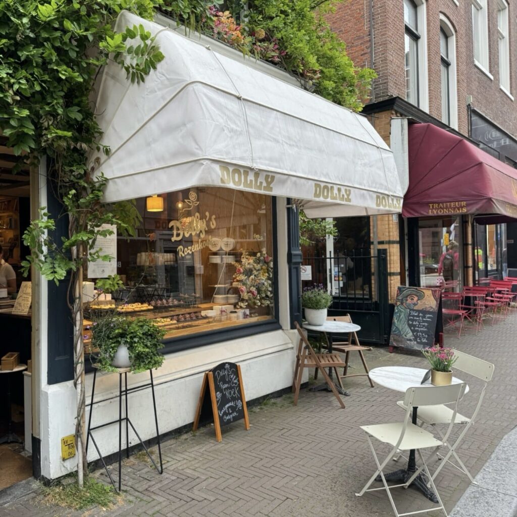 Dolly’s Rozenkoek. ©MaritKruisdijk_ Dolly’s Rozenkoek storefront with outdoor café tables on a street in The Hague.