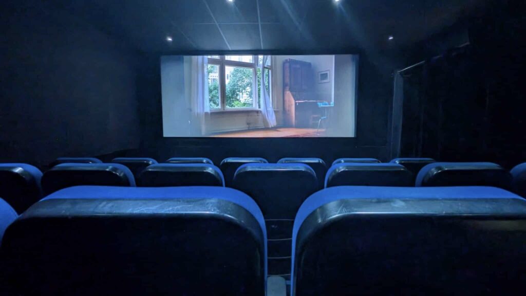 Rows of blue seats facing the screen inside Kino Bajka, a local movie theater in Lublin.