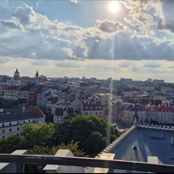 Sunlit view across Lublin’s Old Town rooftops and church towers from Lublin Castle.